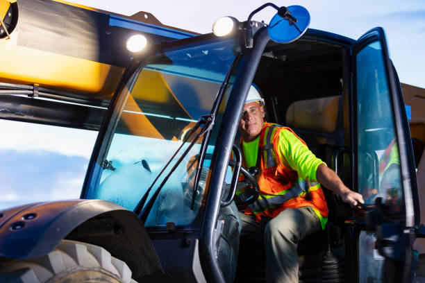 istock Worker operating construction vehicle at jobsite 1907137118
