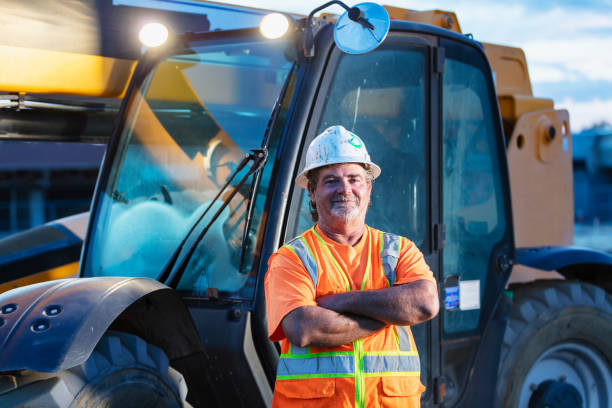 istock Worker standing in front of construction vehicle 1907137135
