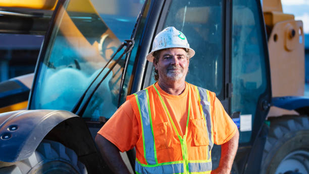 istock Worker standing in front of construction vehicle 1907137136