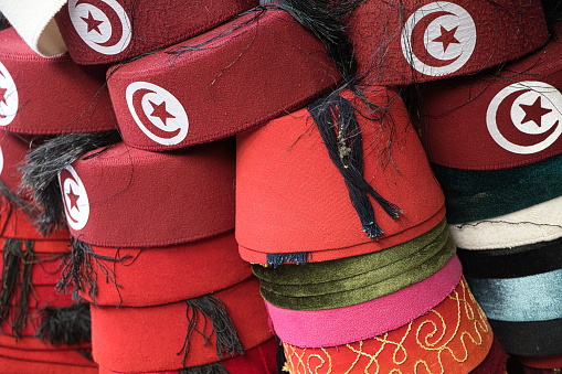 Fez with Tunisian flag and black tassel for sale at a Tunis souk. It is called 'Chechia' and considered in Tunisia to be the national headwear, Tunisia