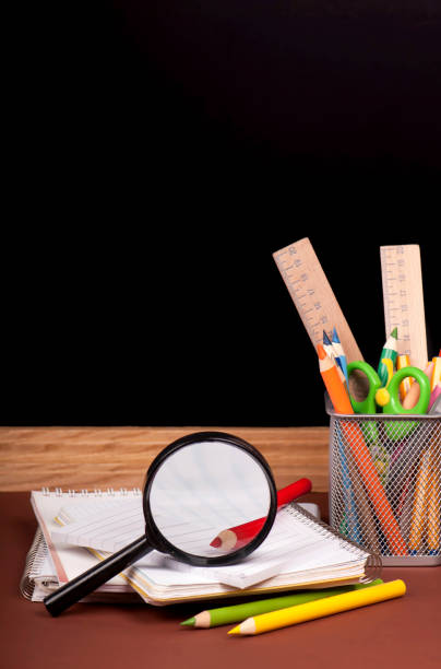 istock board, books, pencils, opened empty notebook against a dark background. 1907139896
