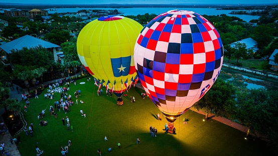 New Braunfels, United States – June 10, 2023: A scenic view of brightly-colored hot air balloons in a park preparing to take off