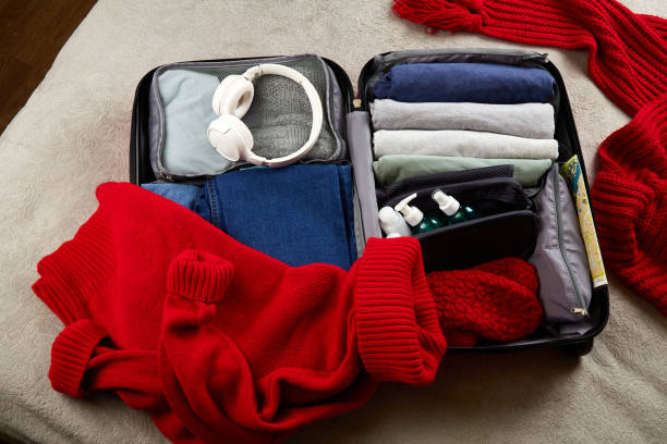 istock An open suitcase with warm clothes, documents and accessories for winter travel 1907147975