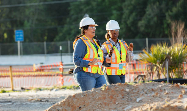 Two multiracial female construction workers at job site