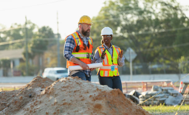 istock Female construction worker with coworker at job site 1907187971