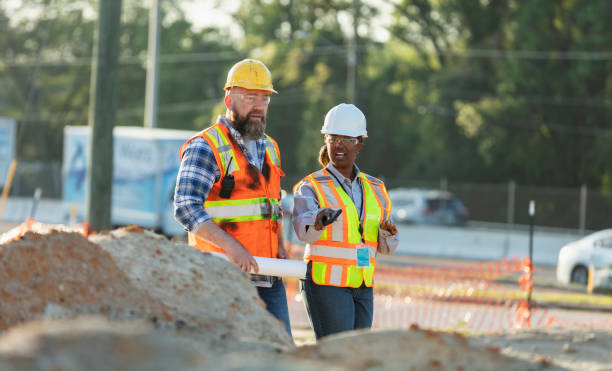 istock Female construction worker with coworker at job site 1907187973