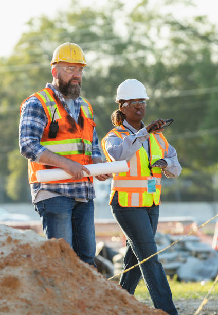 istock Female construction worker with coworker at job site 1907187979