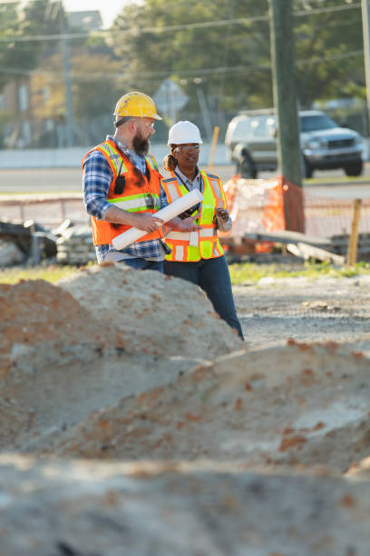 istock Female construction worker with coworker at job site 1907187981