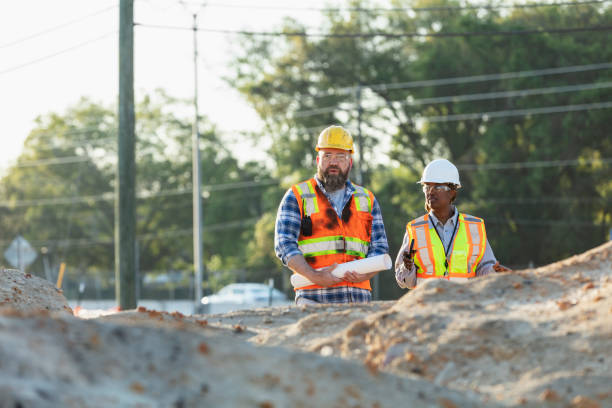 istock Female construction worker with coworker at job site 1907187986
