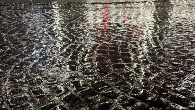 Wet cobblestones at night after rain.