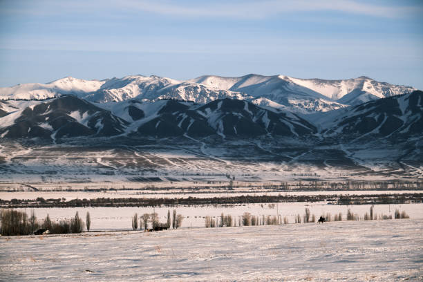 istock Winter view of snow field with remote mountain ridge on background 1907209671