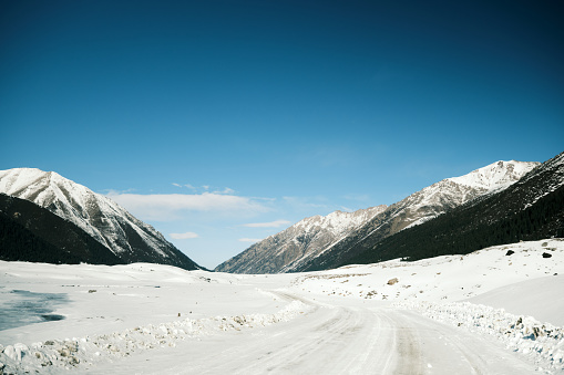 Snow road on wide ravine in Tien Shan mountains in winter