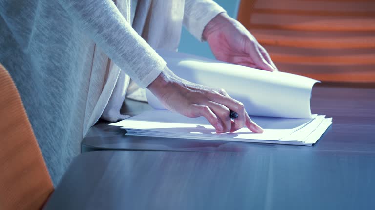 Hands of woman reading papers, writing notes