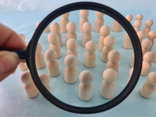 istock Figures of people under magnifying glass and search for candidate 1907260154