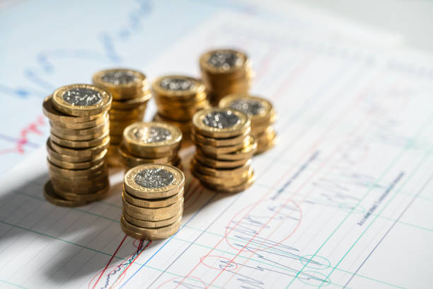 istock Stack of pound coins on financial graphs and figures 1907275982