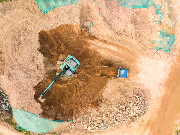 istock Excavator on earthmoving with grab crane unloads sand from freight car 1907294928