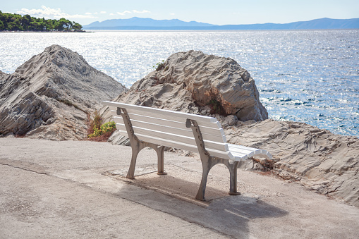 Bench on the sea coast . Seaside resting spot with an ocean view bench