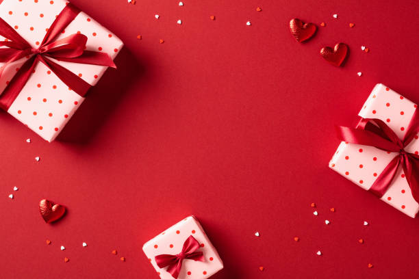 istock Valentine's day flat lay composition with gift boxes and hearts on red table. Top view. 1907322835
