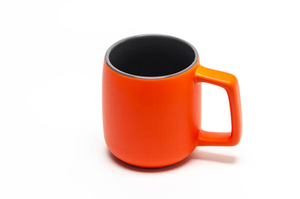 istock Large orange ceramic mug isolated on white background. Dark middle. Copy space. 1907324534