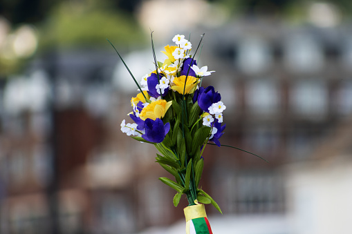 close up of a bunch of fake flowers isolated with buildings in the background