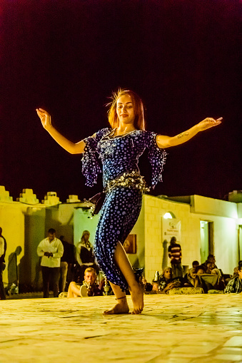 Hurghada, Egypt - December 10, 2018: Young woman performs belly dance at night