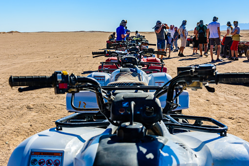 Hurghada, Egypt - December 10, 2018: Unrecognizable people near quad bikes during safari trip in Arabian desert not far from Hurghada city, Egypt