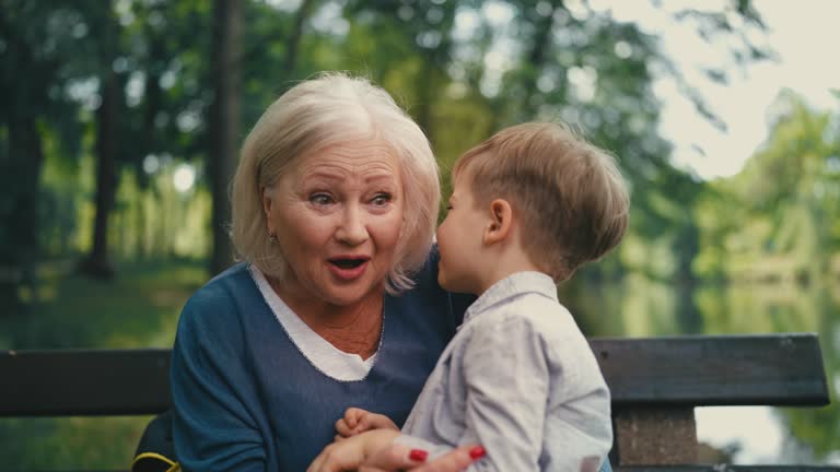 Active grandma joking and playing with little grandson, laughing together, love