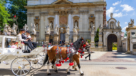 Krakow, Poland - July 18, 2023: Horse carriage in front of Church of Saints Peter and Paul in Krakow Malopolska region in Poland
