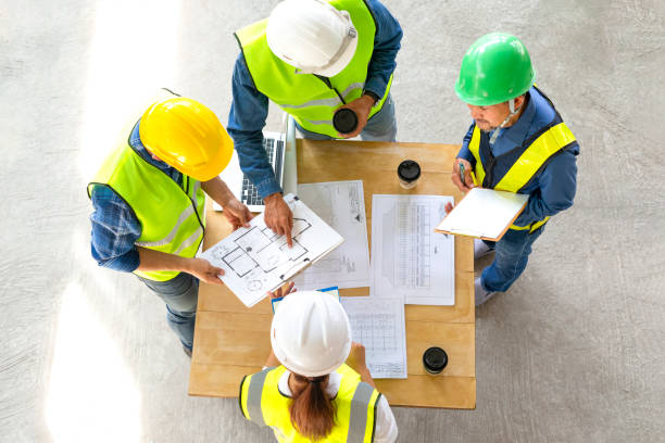 istock top view of engineers team meeting and discussing by using laptop,blueprint and documents on table in the building under construction 1907359407