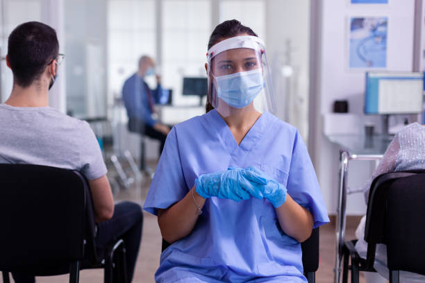 istock Nurse with visor and face mask against coronavirus looking tired at camera 1907362547