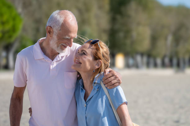 istock Senior couple walking on beach 1907376840