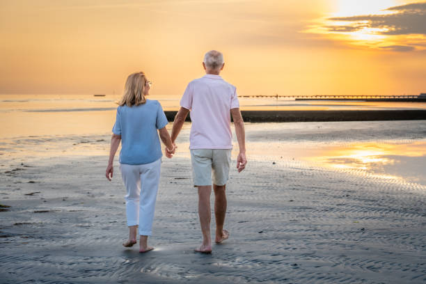 istock Senior couple walking on beach 1907376867