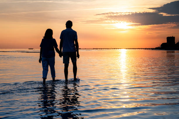 istock Senior couple walking on beach 1907376869