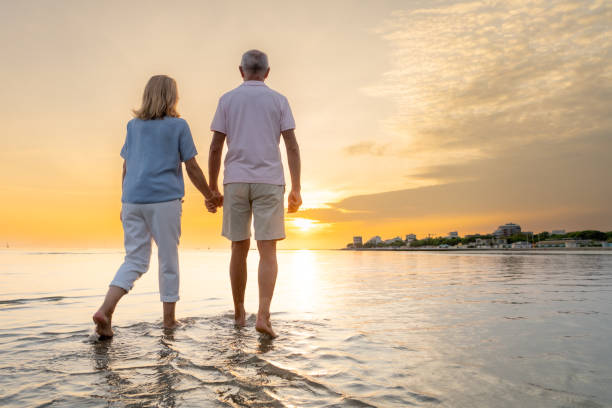 istock Senior couple walking on beach 1907376913