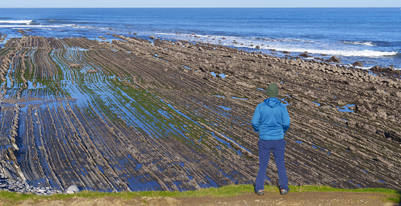 Flysch in the Basque Country. Hiker in the flysch of the tidal rasa between Deba and Zumaia, Basque Country.
