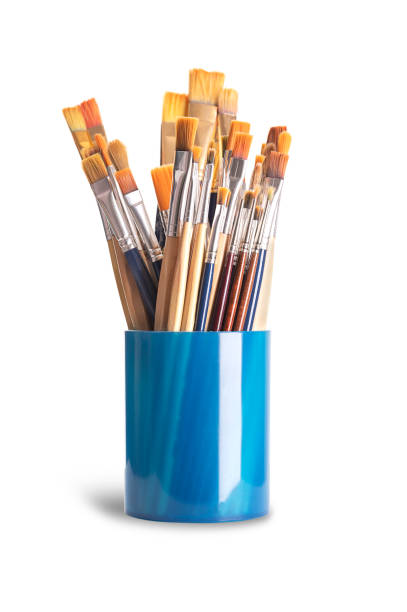 istock Paintbrushes, flat, round and of various sizes, in a blue plastic cup 1907396243