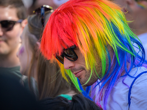 Vienna, Austria - June 17, 2023: People at Vienna Pride in summer on Wiener Ringstrasse, man with sunglasses and colorful wig