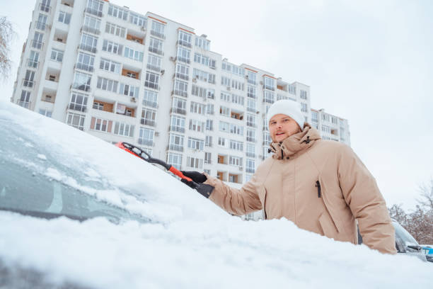 istock man cleaning car out of snow 1907422084