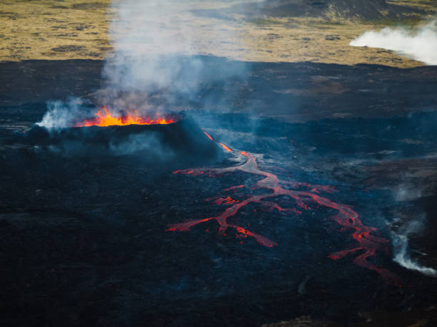 istock Erupting volcano, lava pouring out into a devastated surrounding, drone shot 1907423675