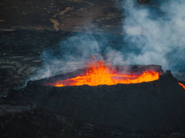 istock Erupted volcano and surroundings, boiling lava flowing, pull away drone shot 1907436773