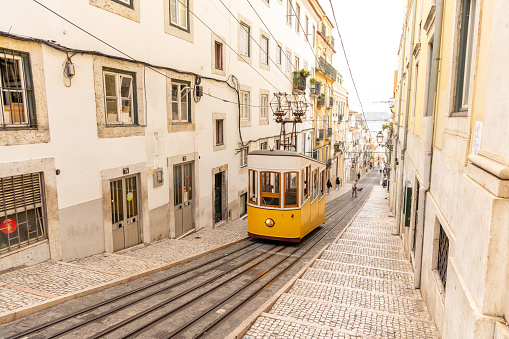 The beautiful sunny Lisbon city in Springtime, famous yellow cable car in the old town.