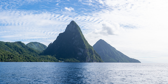 A panorama of the Twin Pitons in St Lucia on a sunny day as seen from the Caribbean Sea.
