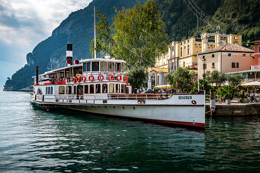 Riva del Garda, Italy - October, 04. 2023:  Empty tourboat at harbor waiting for passengers for the next tour in Riva del Garda in Italy.