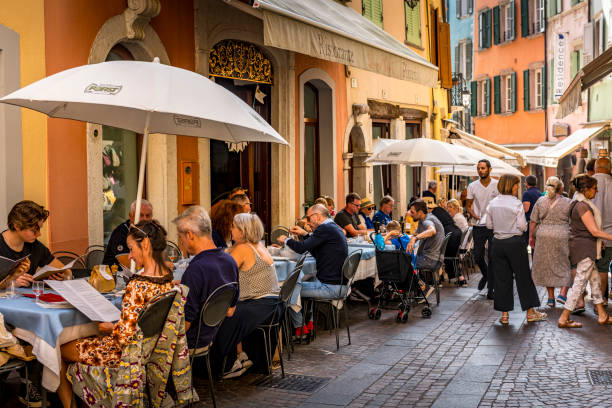 Riva del Garda, Italy - October, 04. 2023: Street with some restaurants at downtown Riva del Garda