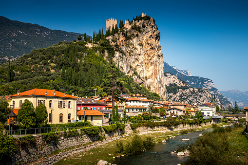 Arco, Italy - October, 01. 2023: Arco with River Sarca and Castello di Arco on top of the hill in Italy