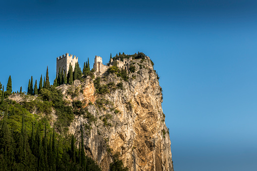 Arco, Italy - October, 01. 2023: Arco with River Sarca and Castello di Arco on top of the hill in Italy