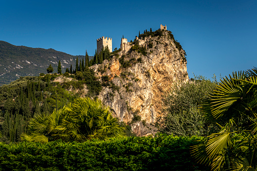 Arco, Italy - October, 01. 2023: Arco with River Sarca and Castello di Arco on top of the hill in Italy