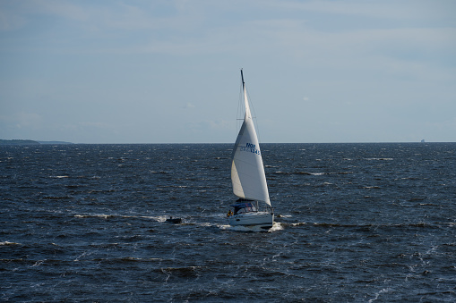Moss, Norway - August 27 2023: Sailboat crossing a fjord in strong wind.