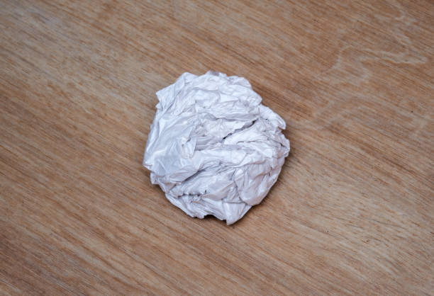 Crumpled paper ball on wooden background. Professional business concept idea.