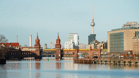 cityscape of Berlin showing spree river, tv tower, and an U-Bahn train crossing the Oberbaumbrücke connecting the districts of Kreuzberg and Friedrichshain